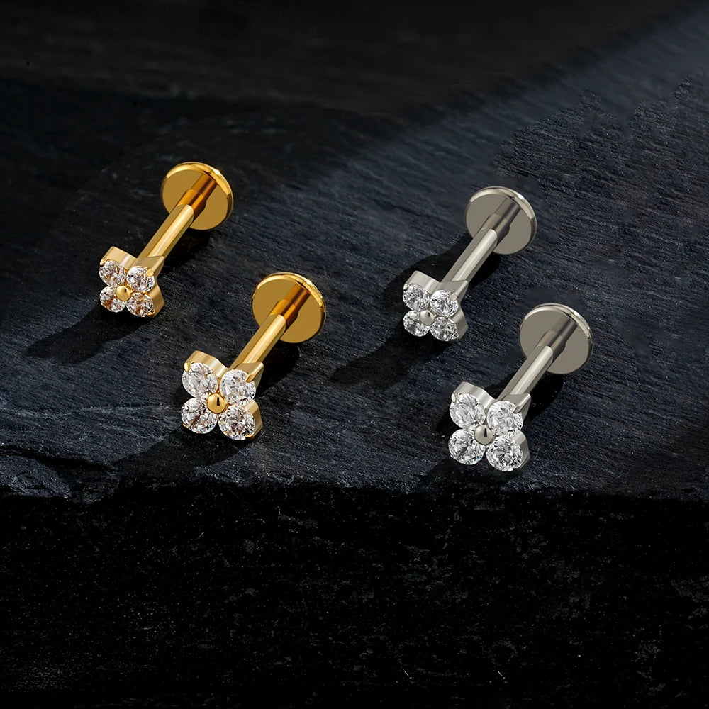 Pair of gold and silver floral stud earrings on a dark surface