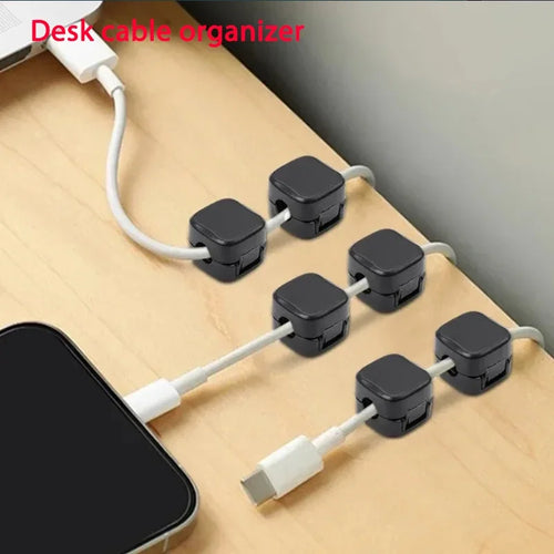 Desk cable organizer with multiple cable clips on a wooden surface.