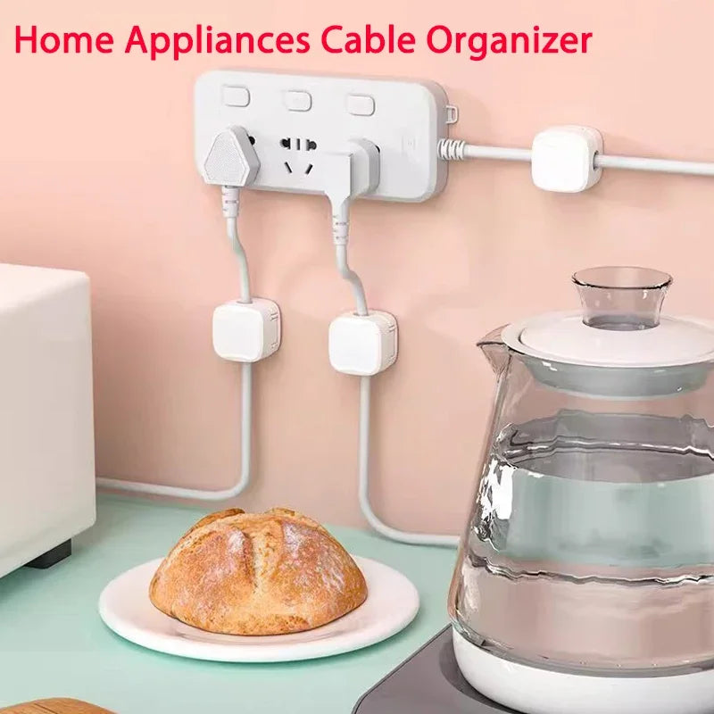 Home appliances cable organizer with a loaf of bread and a glass teapot on a table.